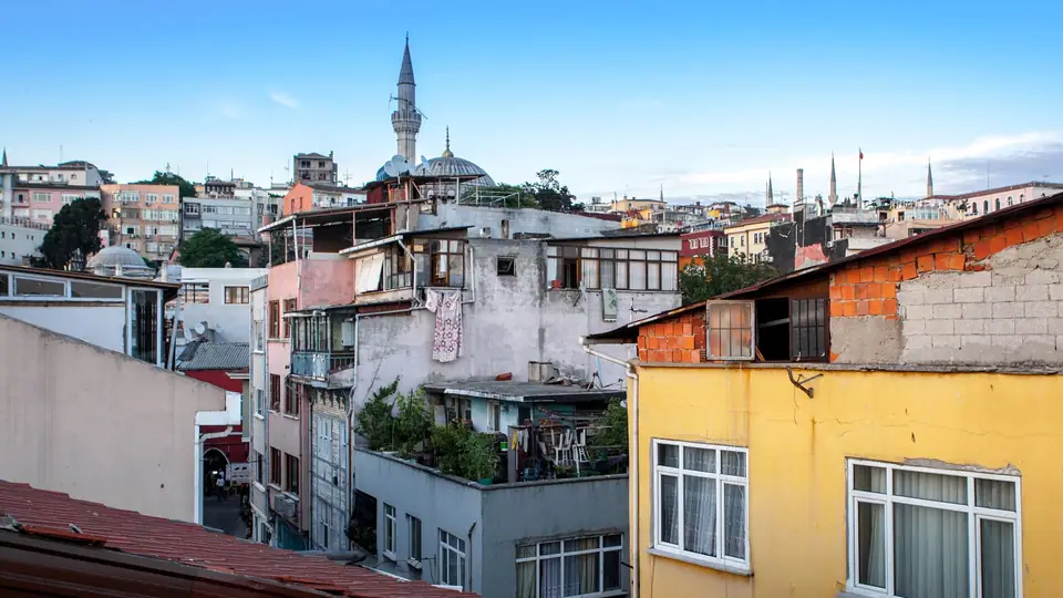 İstanbul’da teraslı ve kiremit çatılı eski binalar, arkada cami minareleri